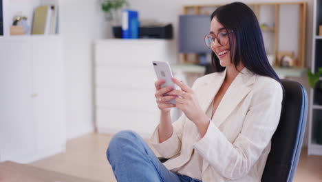 Happy-Businesswoman-Browsing-Social-Media-on-Smartphone-in-Office