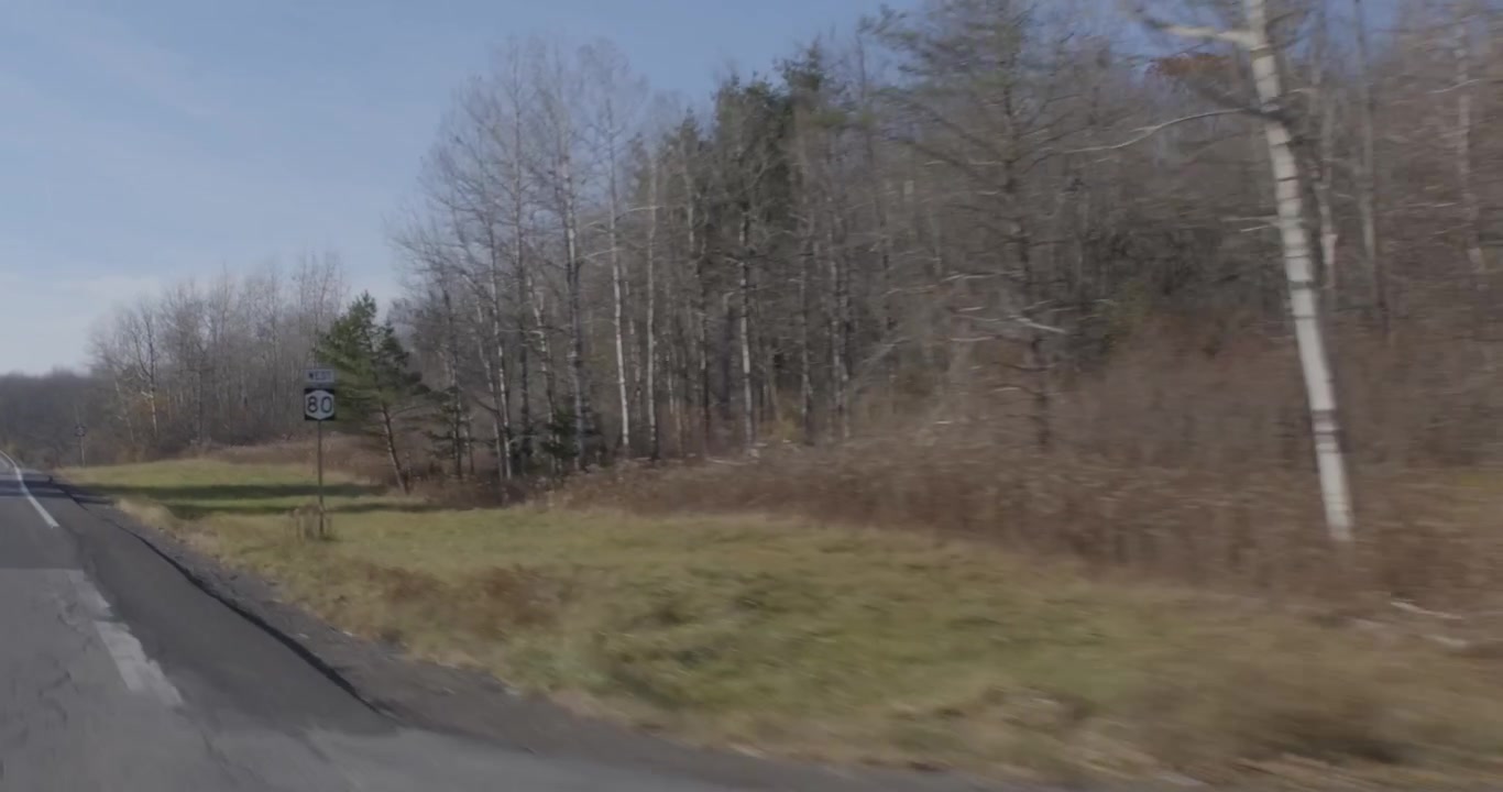Kamerabil langs en landevej i New England på en solrig eftermiddag