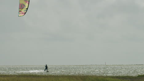 smooth kite surfer handling his kite on the north sea on a sunny afternoon in august