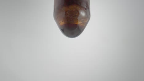 close-up of a brown liquid dripping from a bottle