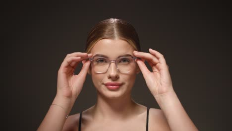 Una-Linda-Joven-Caucásica-Se-Quita-Las-Gafas,-Retrato-De-Estudio