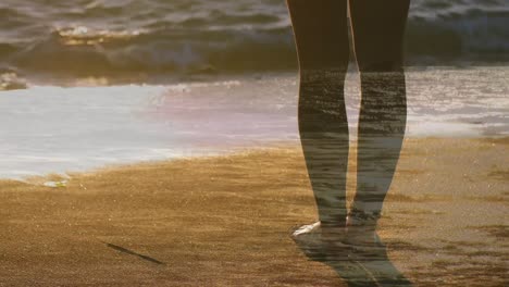 woman standing barefoot on the beach