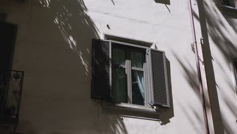 a window with shutters on a building in italy