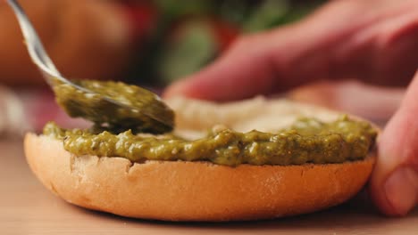 mortadella ham sandwich, traditional italian focaccia filled with thin pesto slices of mortadella, served by chef man in cafe restaurant. macro of traditional italian spanish tapas antipasti.