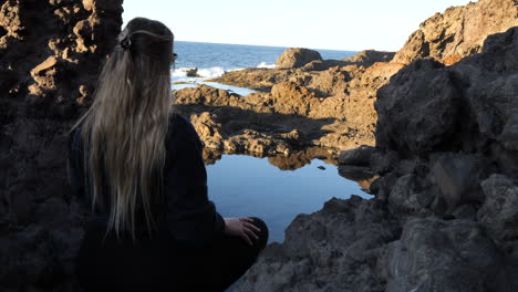 Shot-of-a-woman-admires-one-of-the-natural-pools-found-in-the-municipality-of-Galdar-on-the-island-of-Gran-Canaria-and-during-sunset