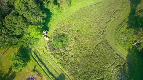 aerial view of tractor cutting grass in the rural fields