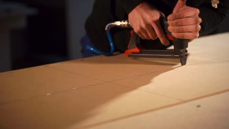 using a nail gun to assemble a wooden panel