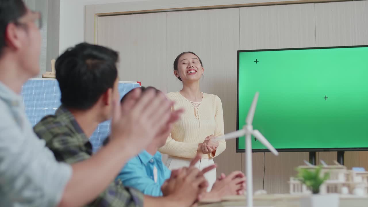 태양전지를 가진 아시아 여성 엔지니어가 사무실에서 녹색 스크린 tv에 대해 성공적으로 프레젠테이션을 하고 관객들이 박수를 치며 인상적 인 느낌을 받았습니다.