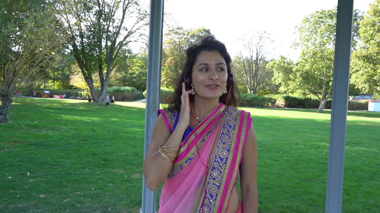 Ragazza in sari che ascolta musica e canta con passione
