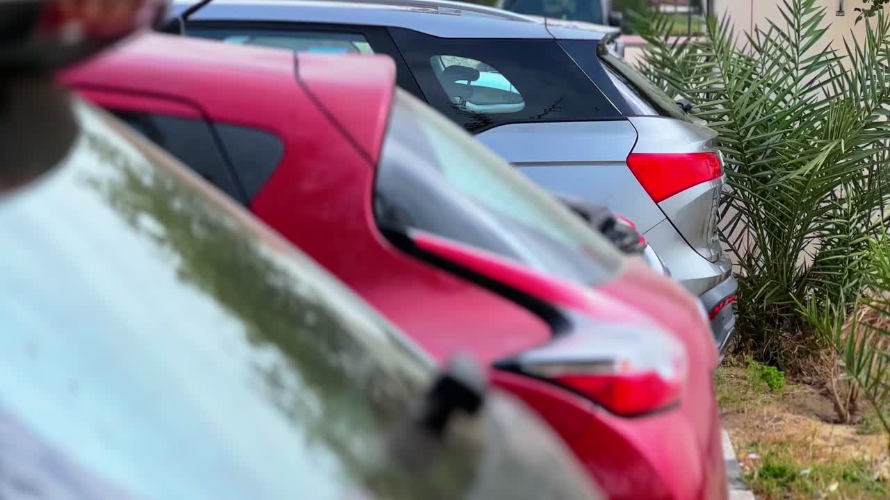 Multiple modern vehicles parked in an outdoor urban lot. Shallow depth of field with vibrant colors. Ideal for traffic, transportation, and city infrastructure themes.