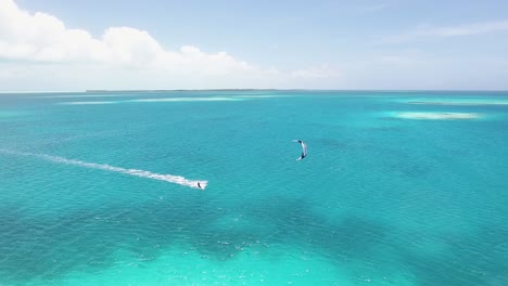 Disparo-De-Un-Dron-Siguiendo-A-Un-Hombre-Haciendo-Kitesurf-En-Aguas-Planas-Del-Mar-Caribe,-Los-Roques