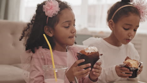 mixed-race girls eating cupcakes at home