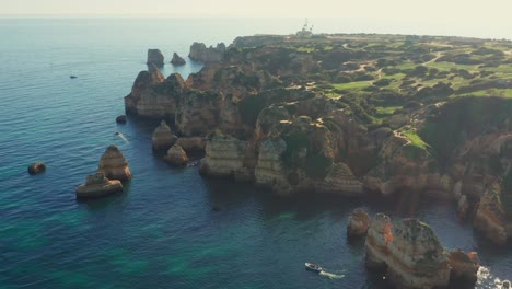 Toma-Aérea-Con-Inclinación-Y-Seguimiento-De-Los-Hermosos-Acantilados-De-La-Región-Del-Algarve-Filmados-En-Lagos,-Portugal