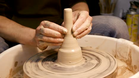 man works with a potter's wheel, only hands