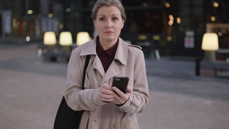 portrait of serious business woman executive browsing checking messages networking using smarphone mobile technology in city evening