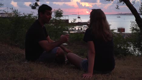 coppia che si godono le bevande al tramonto sulla spiaggia