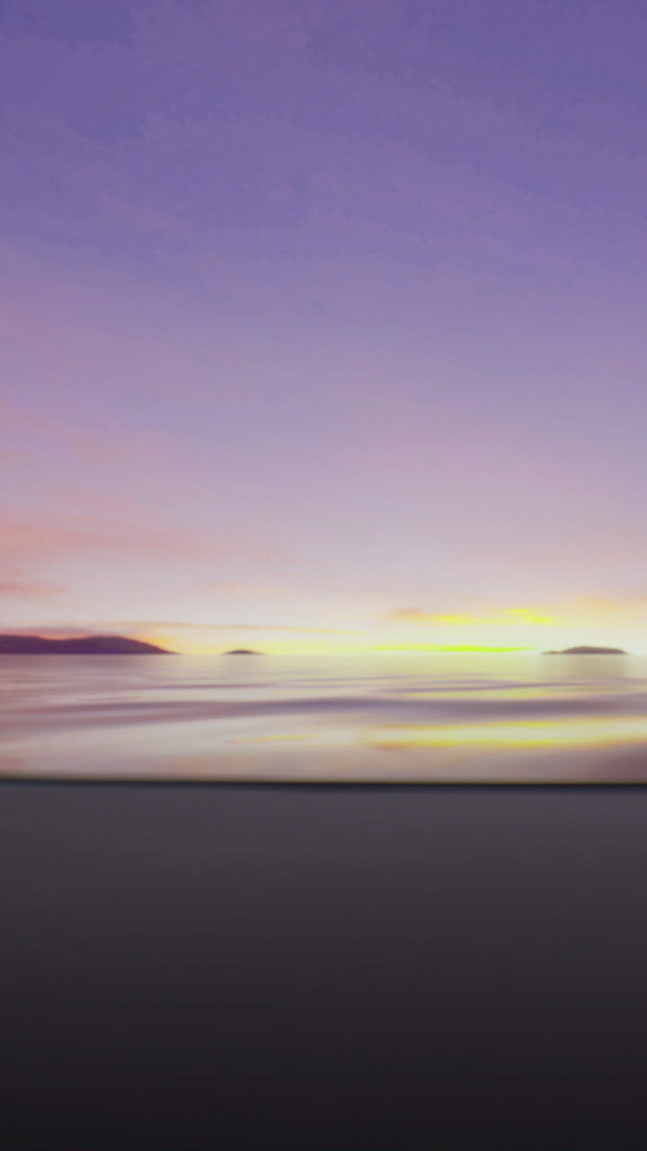 Sunset over the ocean with waves and distant islands along the shore