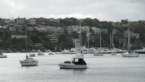 sailboats moored in bay of seaside town on partly cloudy day