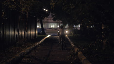 child riding a bike outdoor in late evening