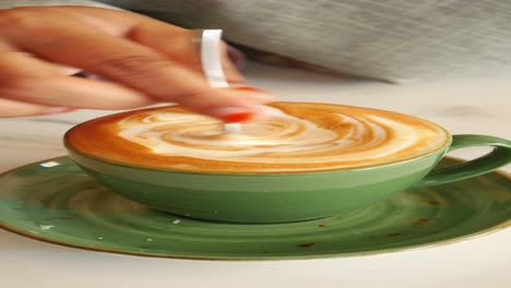 a green cup of coffee with latte art