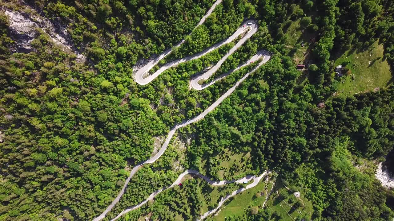toma de drones, vista superior, de una carretera rural eslovena rodeada por un bosque de montaña