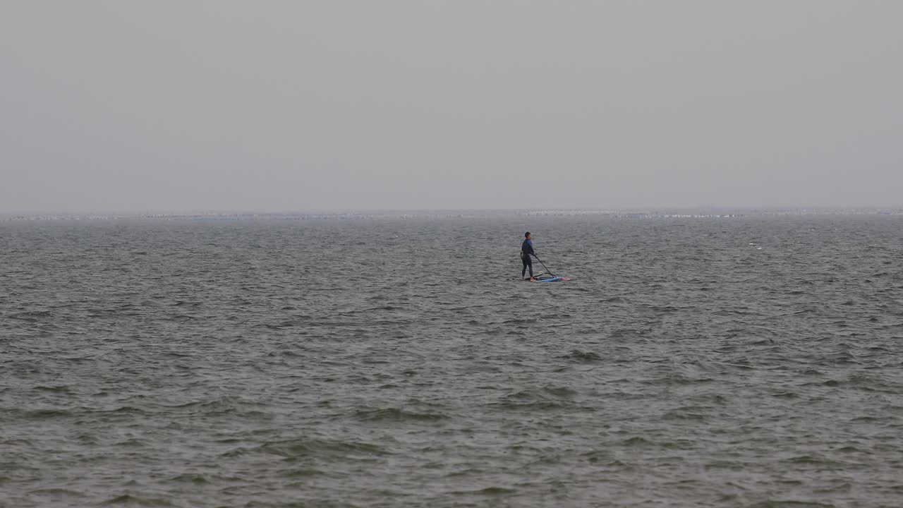태국 파타야에서 흐린 날 바다에서 돛을 당기려고 하는 윈드서퍼