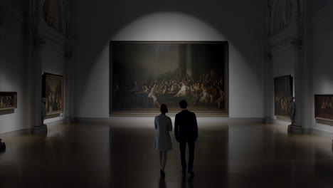 couple admiring a large painting in a dimly lit art gallery