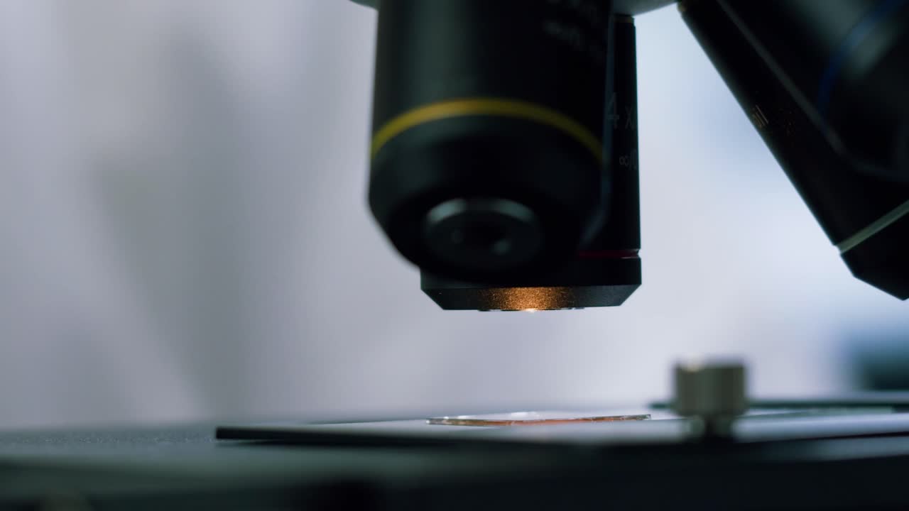 Microscope Focusing on a Sample Slide in a Laboratory