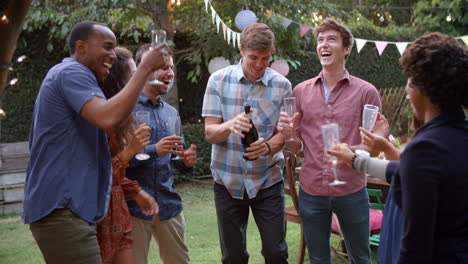 friends celebrating with champagne at outdoor backyard party