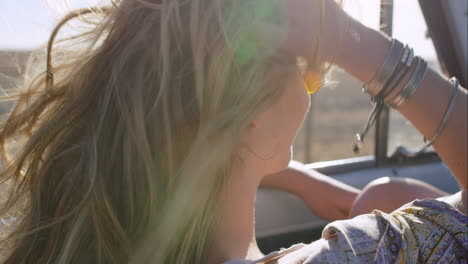 beautiful blonde friend enjoying road trip in vintage convertible car