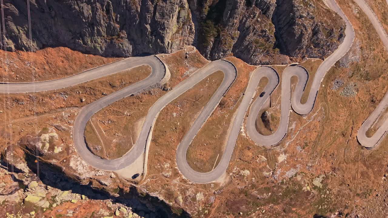 Drone perspective of La Tremola winding across alpine terrain, Switzerland