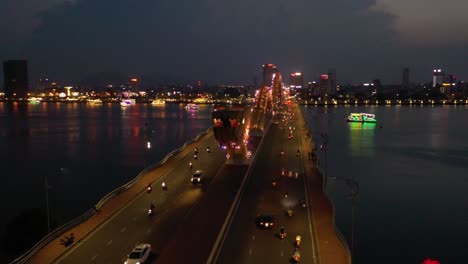 asombrosa foto aérea colorida del icónico puente del dragón cau rong, el tráfico y el horizonte de la ciudad por la noche en danang, vietnam
