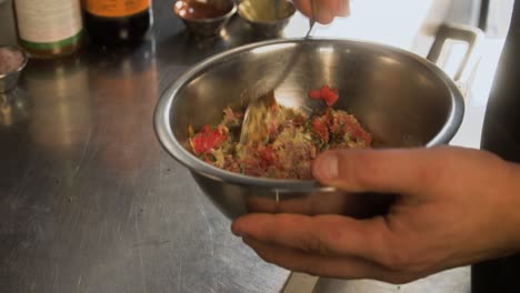 chef mezclando carne tártara dentro de una cocina