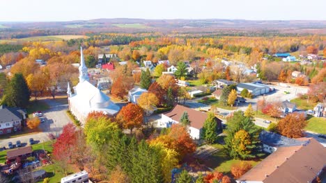 aerial view of name in the estrie region of quebec, canada, showcasing a picturesque village scene with vibrant autumn foliage surrounding houses and a church