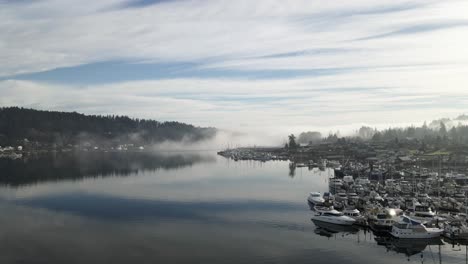 Thick-fog-slowly-rolls-into-the-mouth-of-Gig-Harbor-Washington,-aerial-dolly