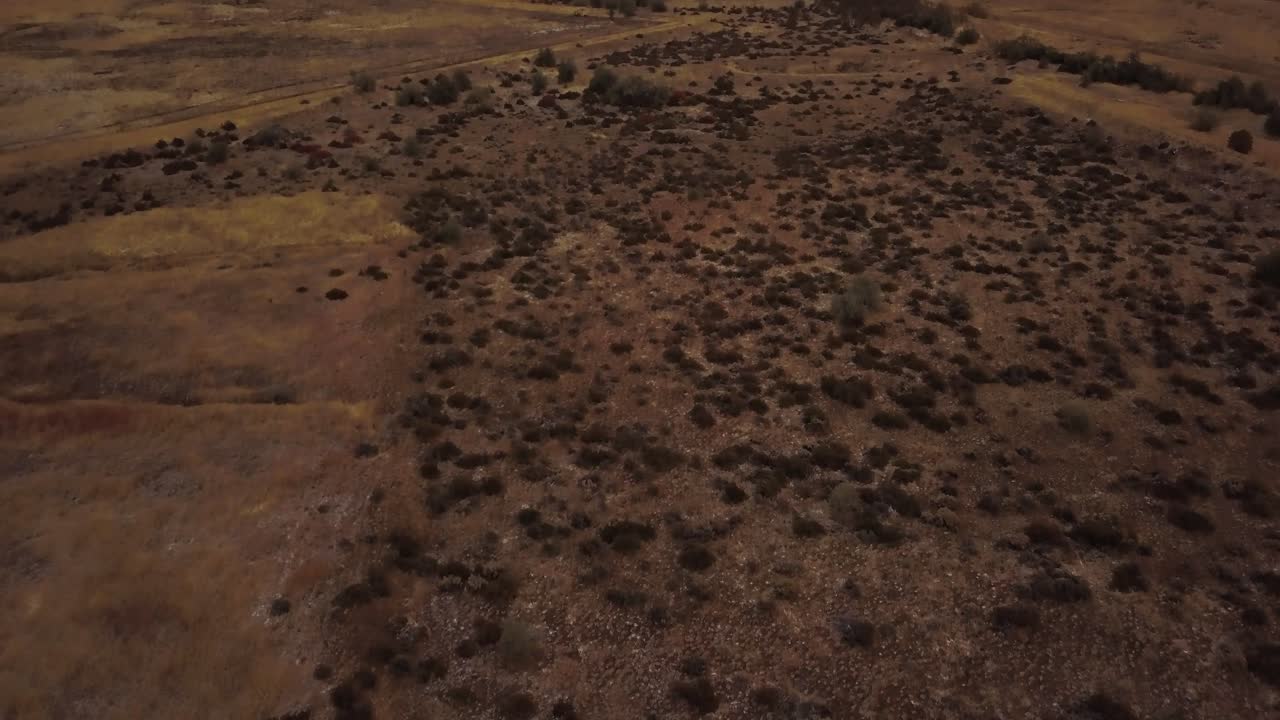 un dron panorámico desde las tierras desérticas de utah para revelar la cordillera nevada parcialmente cubierta en el fondo