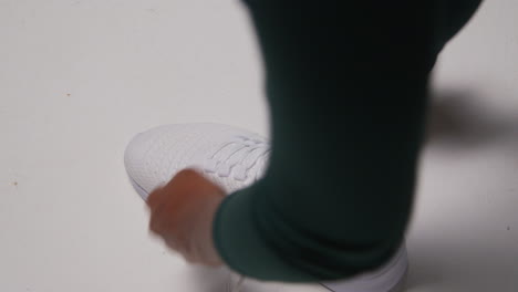 close up of female athlete in gym or changing room tying laces of training shoe before exercising 2