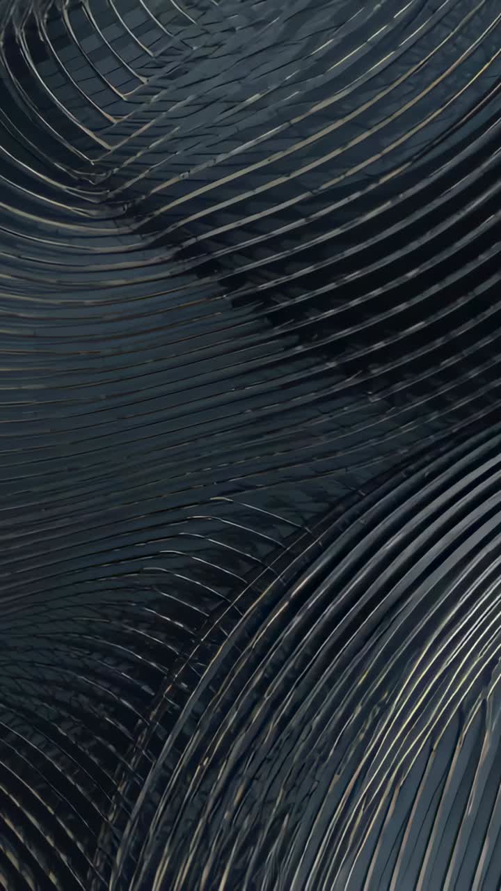 Vertical video: Lighting sweeping dark grooved metal shifting in macro view revealing spiral sheen