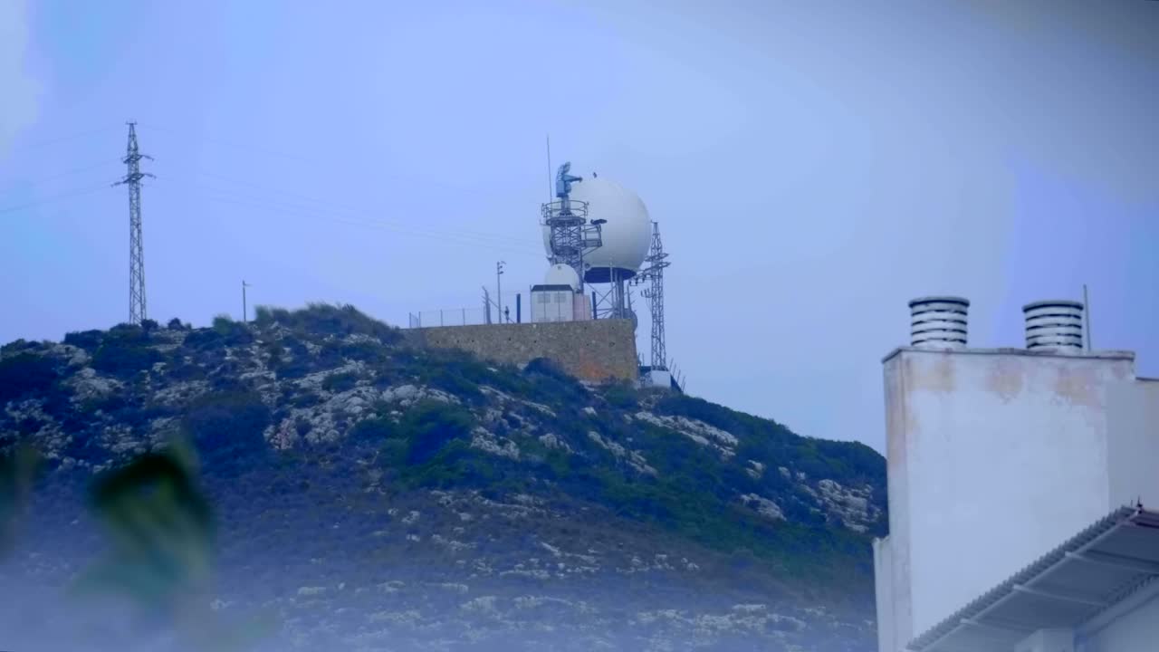 산 꼭대기에 큰 색 구를 가진 기상 레이더