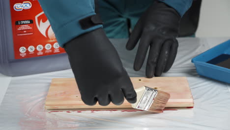 aplicación de la mancha de madera con guantes de protección