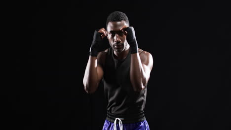 african american boxer in a boxing stance on a black background