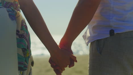 couple holding hands on the beach