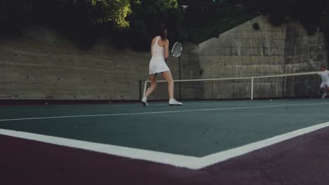 woman and man playing tennis on a sunny day