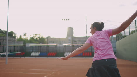 Seitenansicht-Einer-Jungen-Kaukasischen-Frau,-Die-Auf-Einem-Platz-Tennis-Spielt-Und-In-Zeitlupe-Einen-Ball-Zurückschlägt