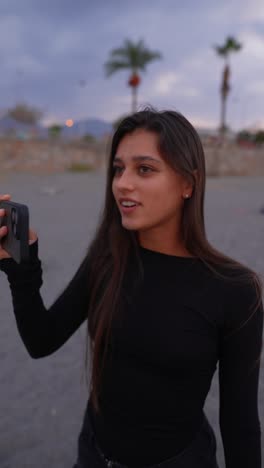 woman on beach looking at phone