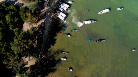 Overhead-aerial-drone-shot-of-Rawai-Beach-where-a-fishing-village-is-located-at-the-tip-of-Phuket-island,-near-Promthep-Cape-in-Southern-Thailand