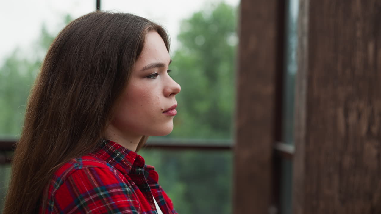 la dama examina el mundo más allá del vidrio expansivo. la expresión abandonada de la mujer desentraña un intrincado tapiz de luchas internas. un laberinto de emociones intrincado mundo interior.