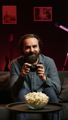 vertical video excited man holding controller in apartment, playing videogames