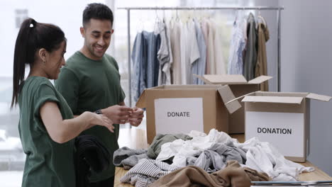 two people wearing green t-shirts while folding