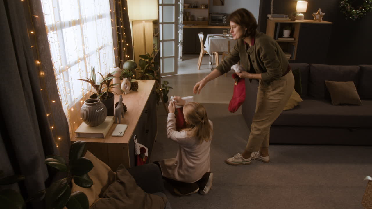 Family decorating living room with Christmas stockings